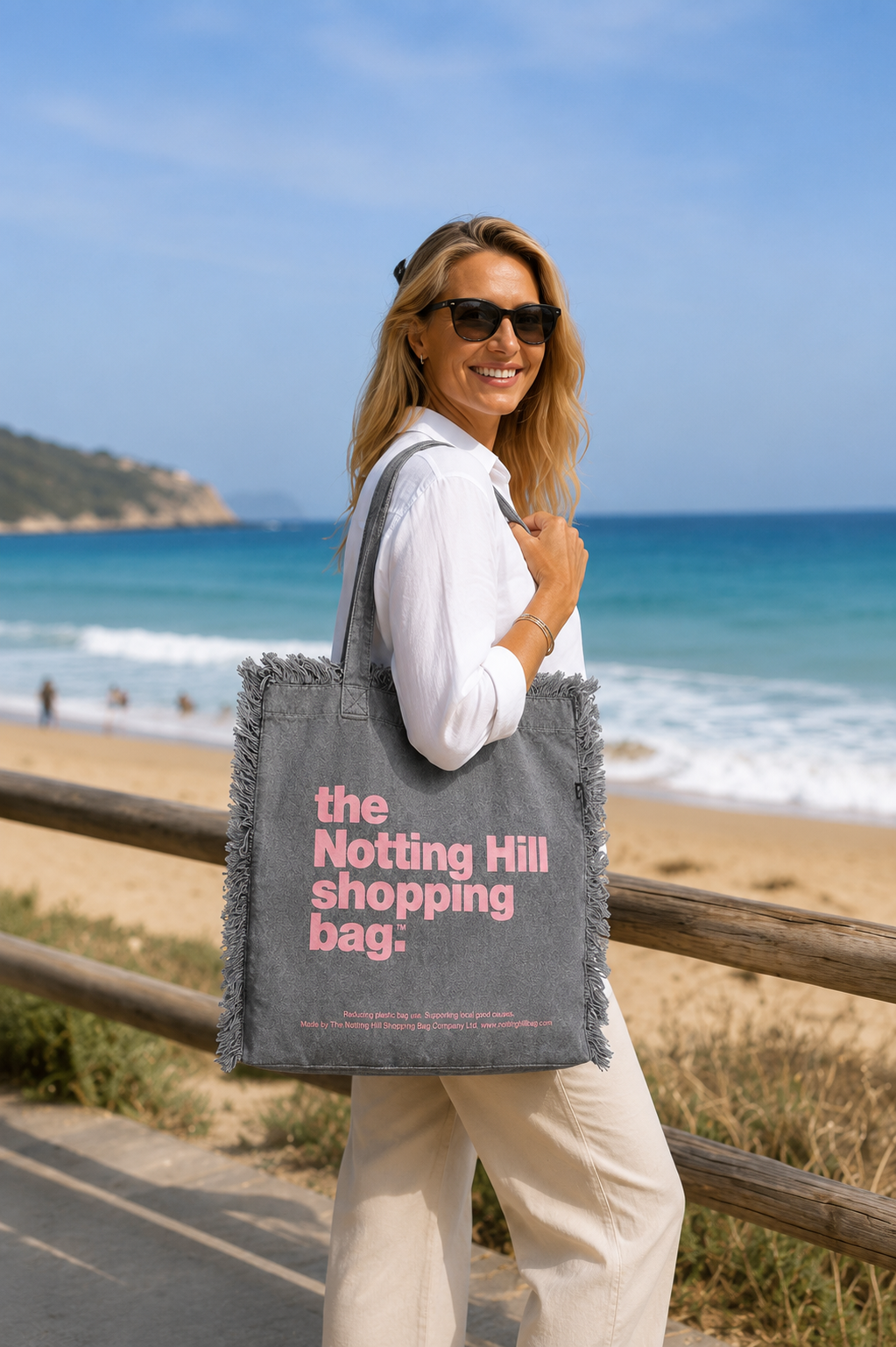 A woman carrying a Grey, Freyed Notting Hill Shopping Bag, tote bag, at the beach