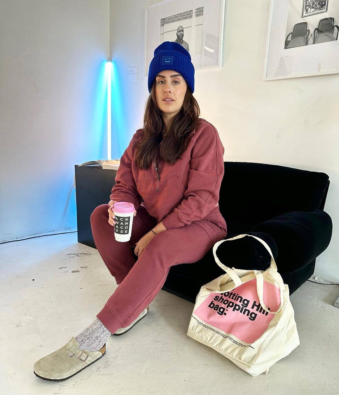 A woman with a Notting Hill Shopping Bag, Pink Colour Block range, sitting on a couch