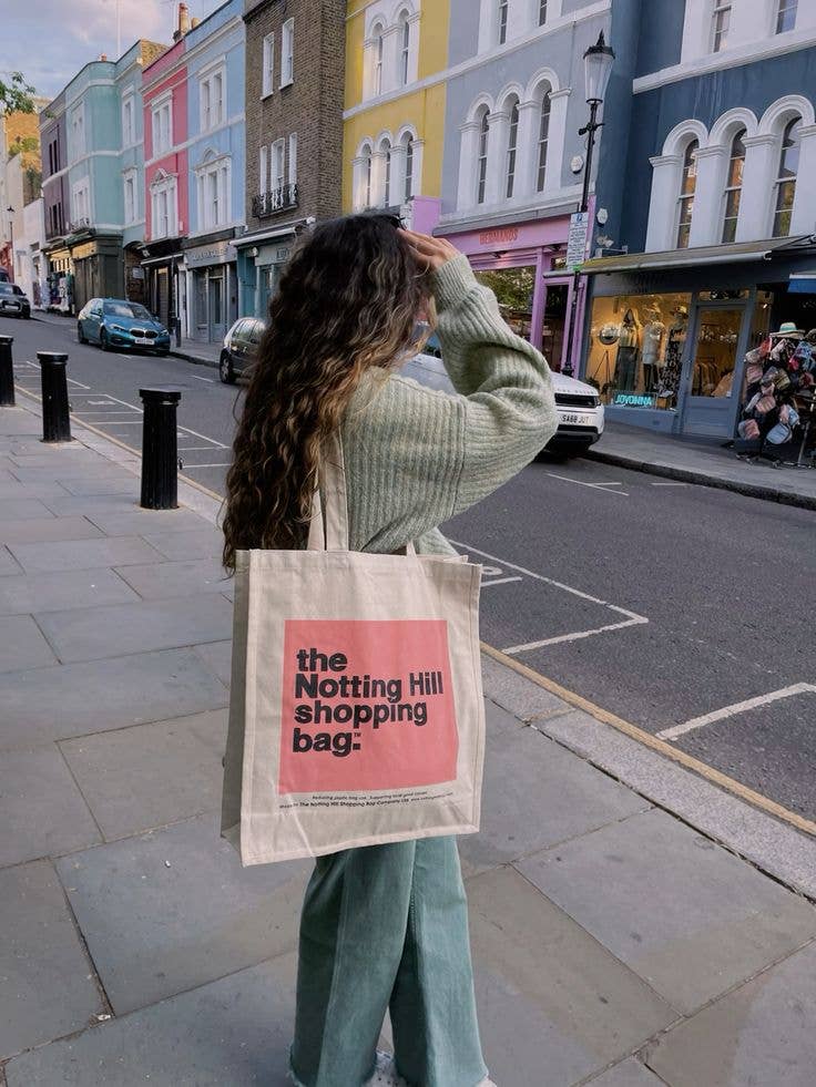 a Woman carrying a Notting Hill Shopping Bag, Pink Colour Block range, walking on Portobello RD, Notting Hill