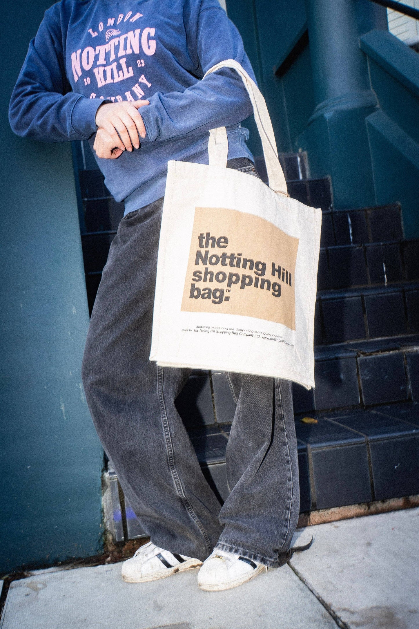A girl on a street, holding a Notting Hill Shopping Bag, in the Beige colour block series