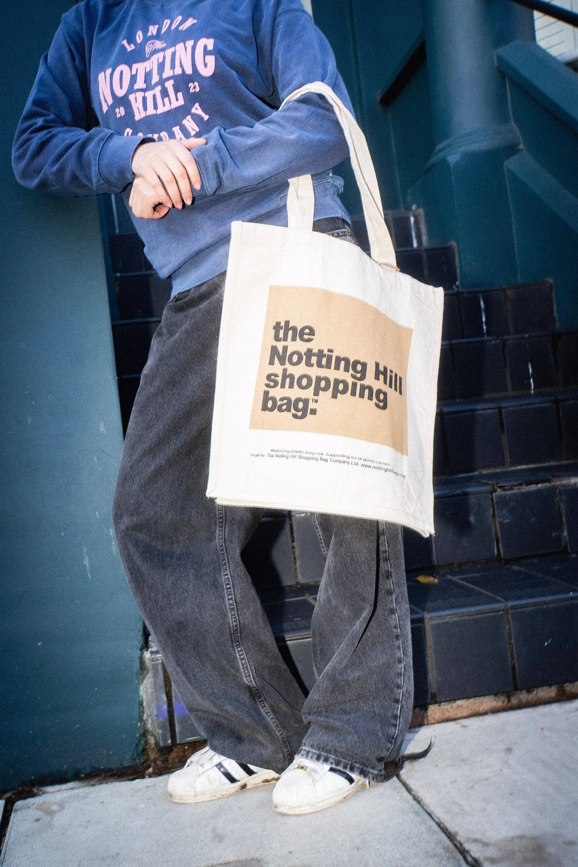 A girl on a street, holding a Notting Hill Shopping Bag, in the Beige colour block series
