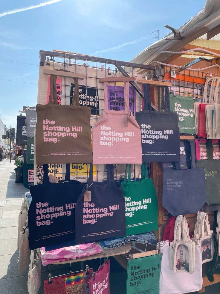A colorful selection of Notting Hill Shopping Bags, on display on Portabello Rd, near Portabello Road Markets