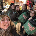 A group of woman holding Notting Hill Shopping Bags, all from the hand dye collection, in green